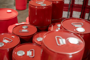 red metal drums of fragrance oil lined up on warehouse floor